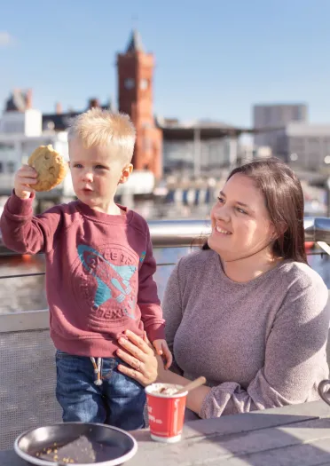 Mam a phlentyn yn mwynhau paned a hufen iâ yn Coffi Co, Bae Caerdydd.