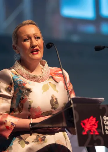 Llun o Rebecca Evans AS, Ysgrifennydd y Cabinet dros yr Economi, Ynni a Chynllunio yn croesawu pawb ir gwobrau.