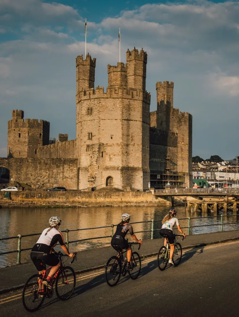 Tri beiciwr yng Nghaernarfon ar Ffordd Brailsford, Gogledd Cymru