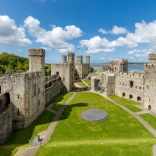 Y tu mewn i dir castell gyda golygfeydd o'r môr.