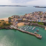 Yr olygfa wrth edrych i lawr ar yr harbwr, y castell a’r traeth yn Ninbych-y-Pysgod