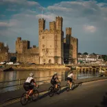 Tri beiciwr yng Nghaernarfon ar Ffordd Brailsford, Gogledd Cymru